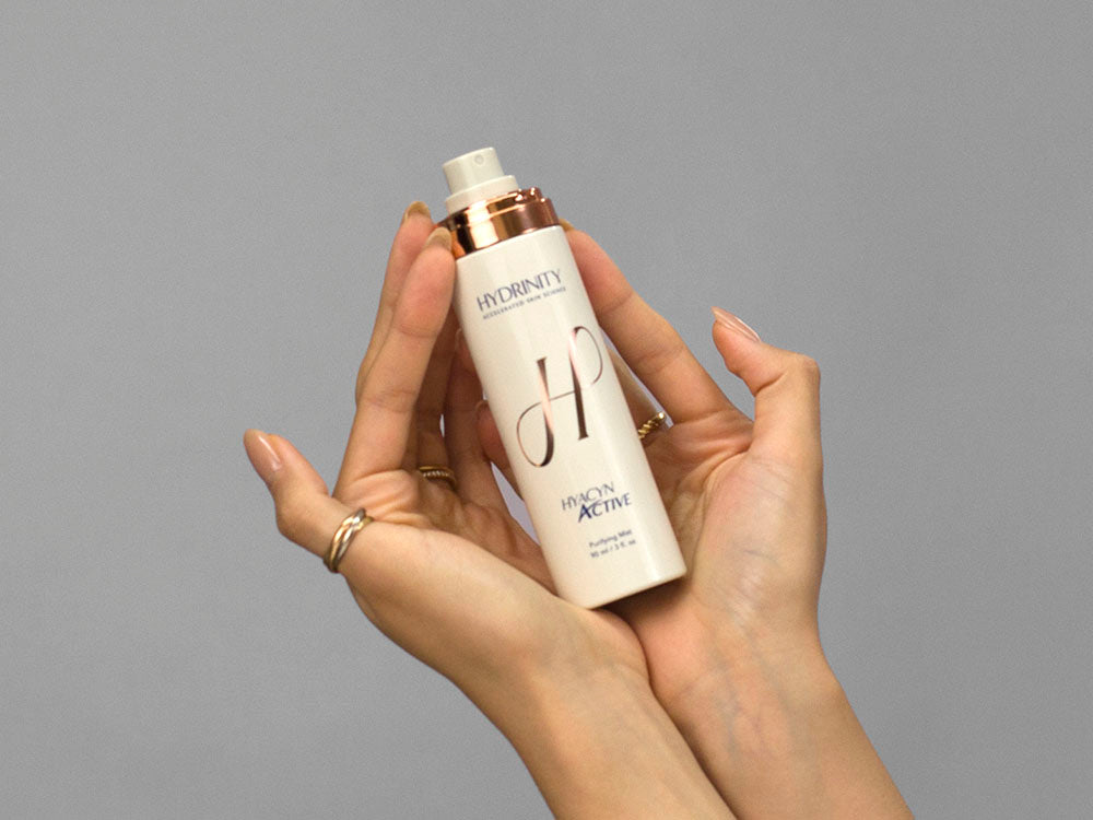 Closeup of Laziza from LAZ Skincare holding up a bottle of Hydrinity Hyacyn Active Purifying Mist