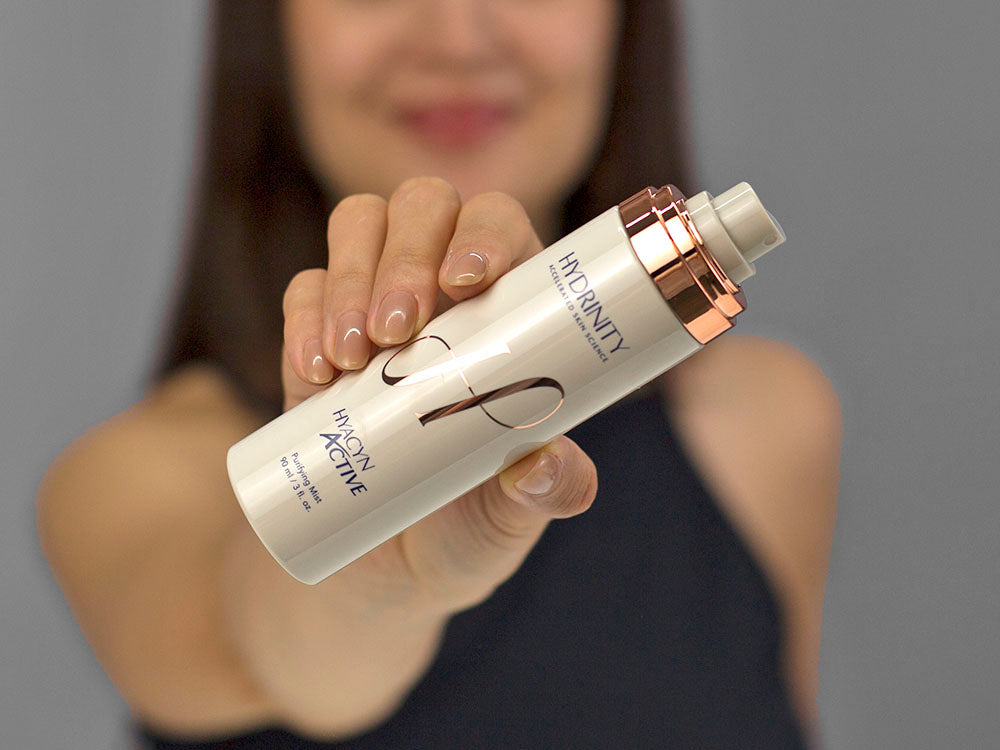 Laziza from LAZ Skincare demonstrating the texture and application of Hydrinity Hyacyn Active Purifying Mist on her hand