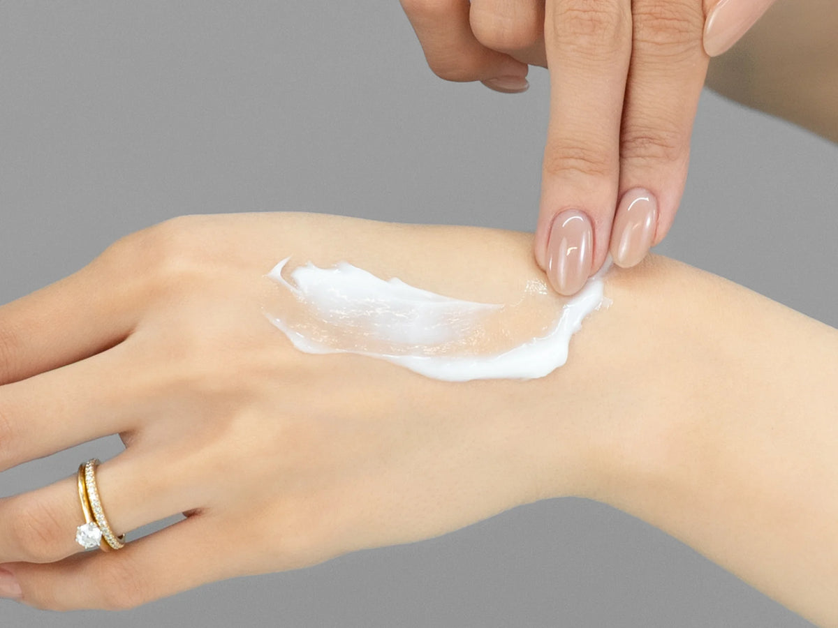 Laziza from LAZ Skincare demonstrating the texture and application of Hydrinity CELTHERA Advanced Overnight Repair Cream on her hand