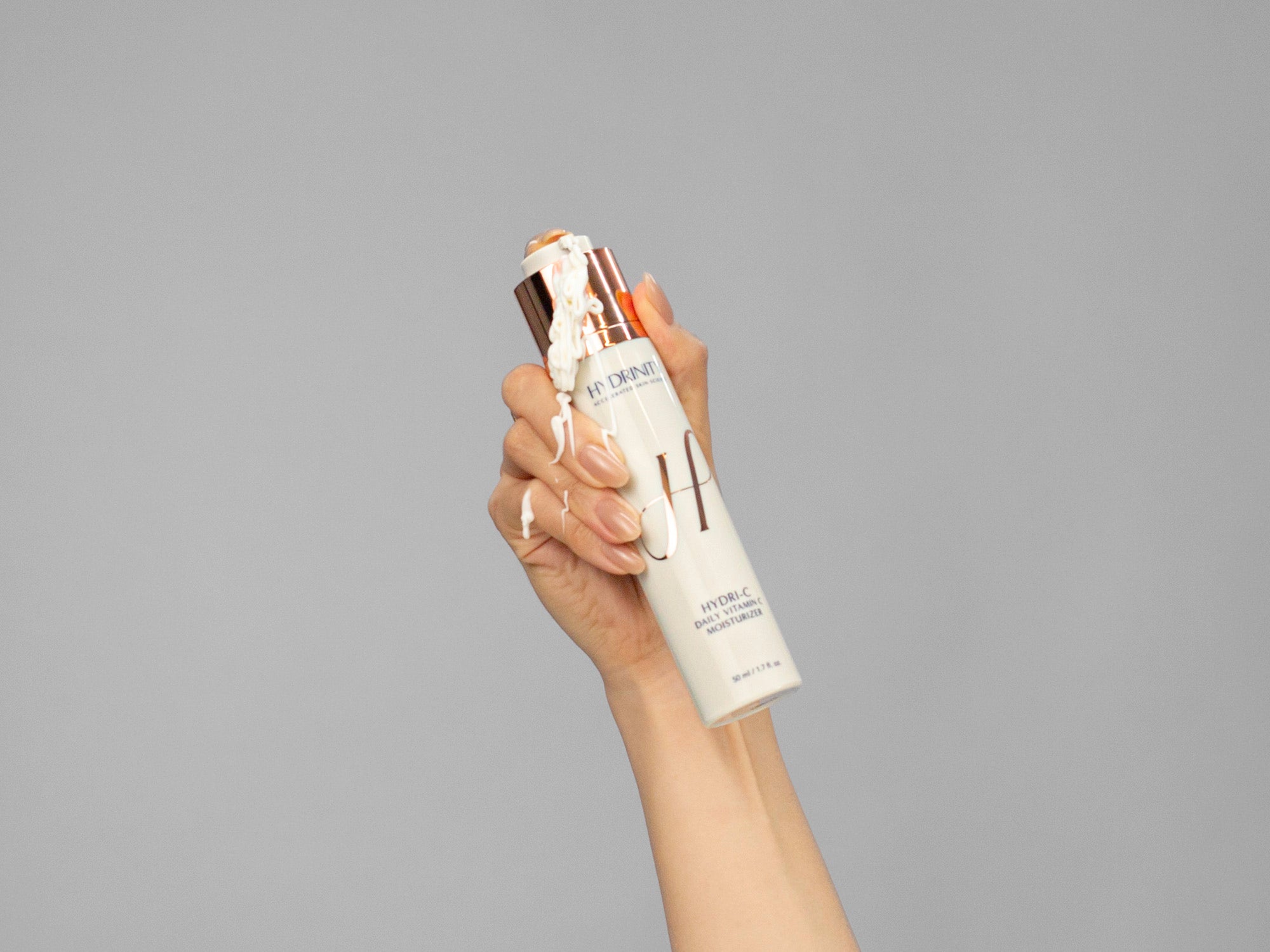 Closeup of Laziza from LAZ Skincare holding a bottle of Hydrinity HYDRI-C Daily Vitamin C Moisturizer in her hand