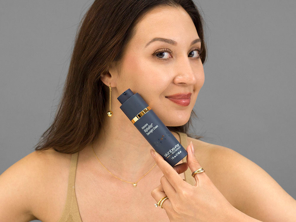 Closeup of Laziza from LAZ Skincare holding up a bottle of SkinBetter Science Intensive AlphaRet Overnight Cream