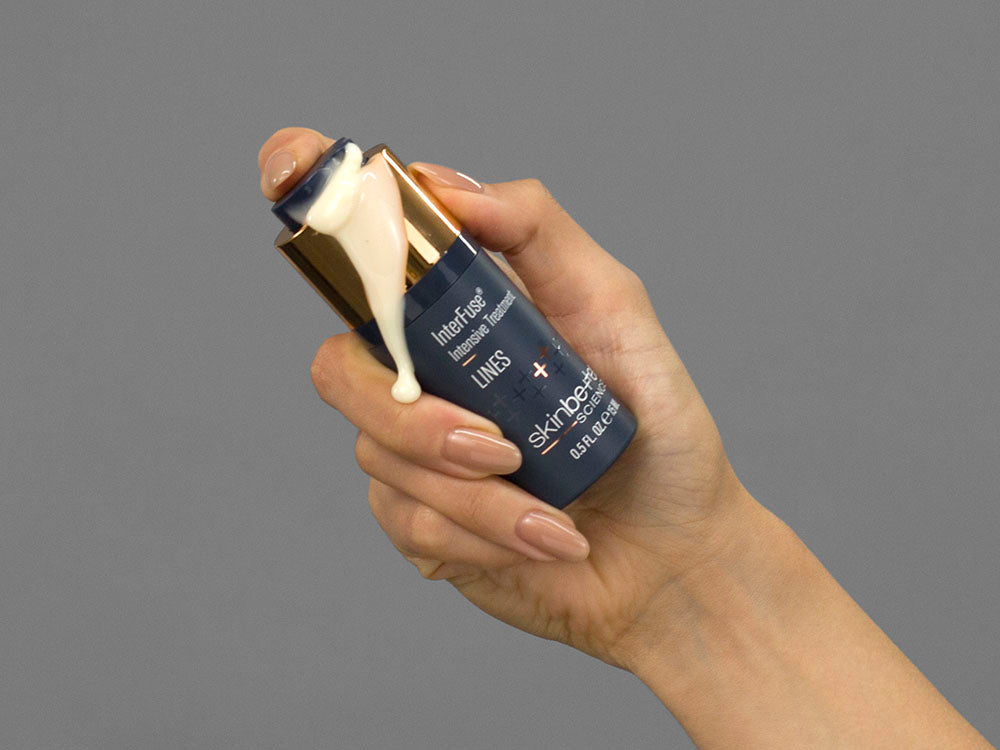 Closeup of Laziza from LAZ Skincare holding up a bottle of SkinBetter Science InterFuse Intensive Treatment LINES