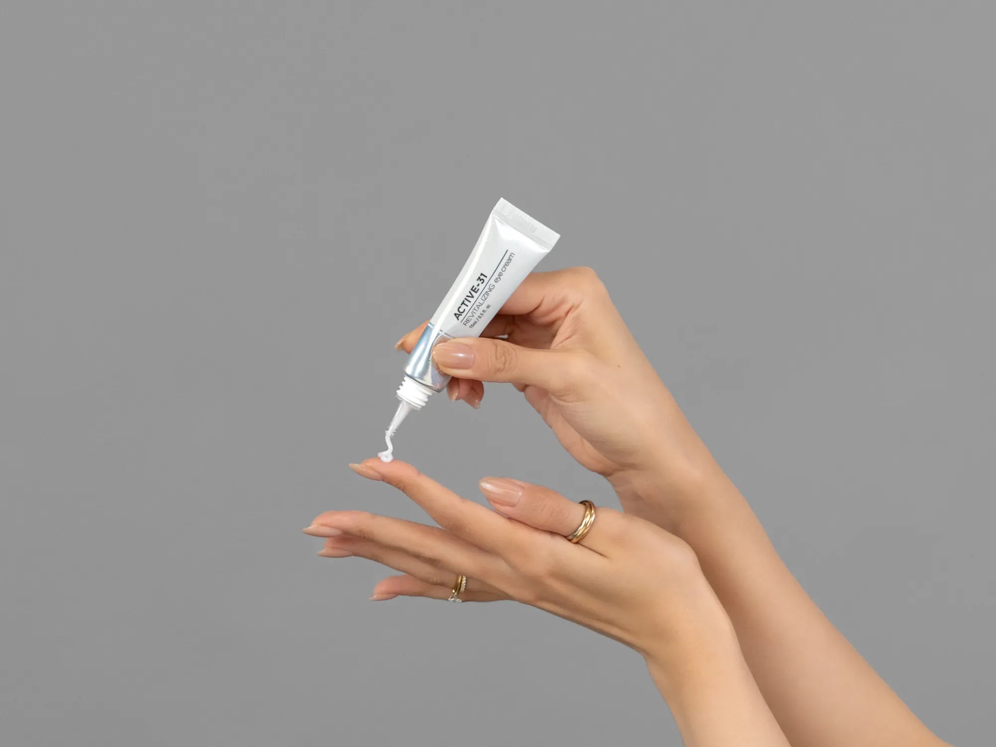 Closeup of Laziza from LAZ Skincare holding up a bottle of KrX Aesthetics Active 31 Revitalizing Eye Cream