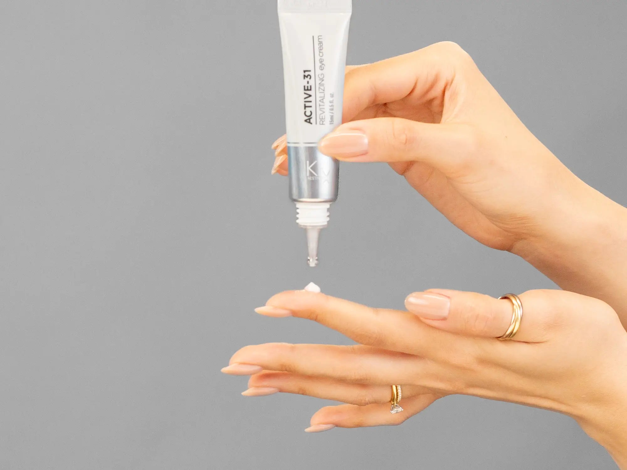 Closeup of Laziza from LAZ Skincare holding up a bottle of KrX Aesthetics Active 31 Revitalizing Eye Cream