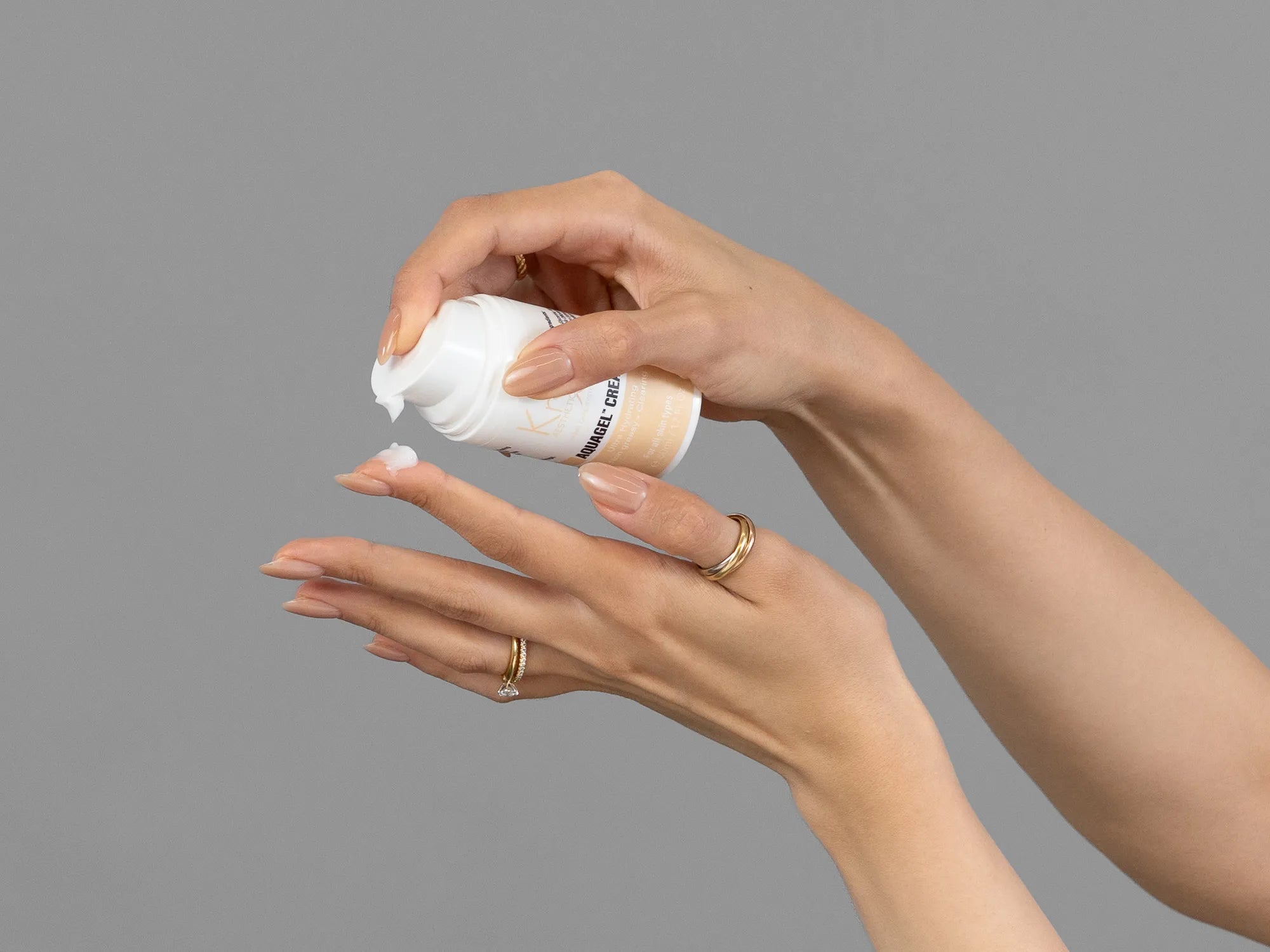 Closeup of Laziza from LAZ Skincare holding up a bottle of KrX Aesthetics AquaGel Cream