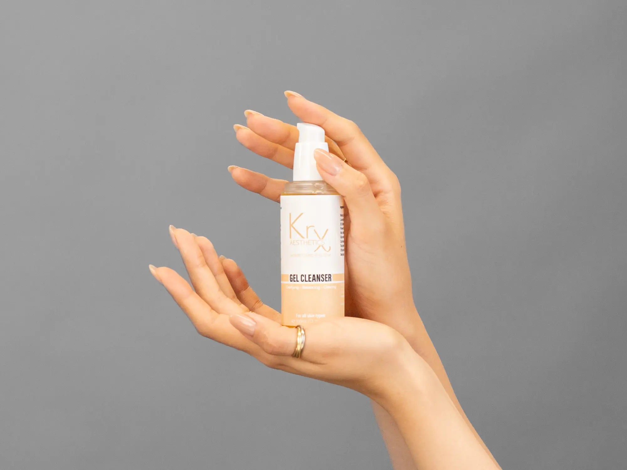 Closeup of Laziza from LAZ Skincare holding up a bottle of KrX Aesthetics Glow Gel Cleanser