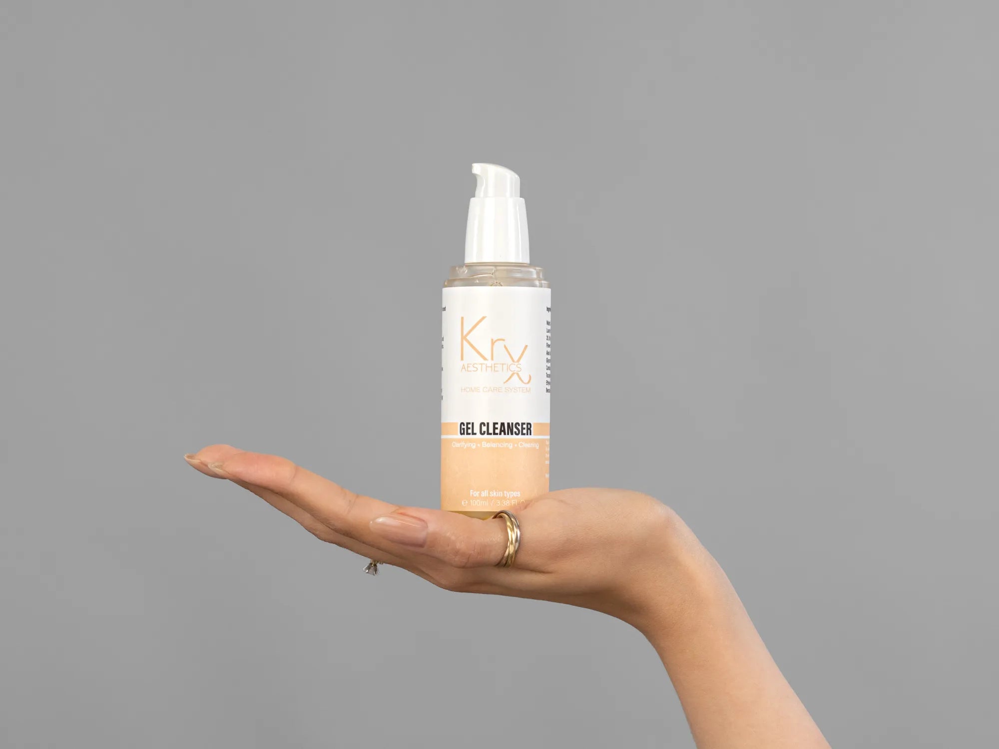 Closeup of Laziza from LAZ Skincare holding up a bottle of KrX Aesthetics Glow Gel Cleanser