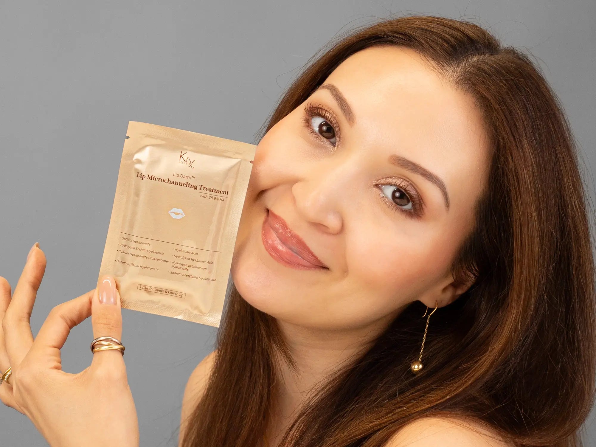 Closeup of Laziza from LAZ Skincare holding up a bottle of KrX Aesthetics Lip Darts