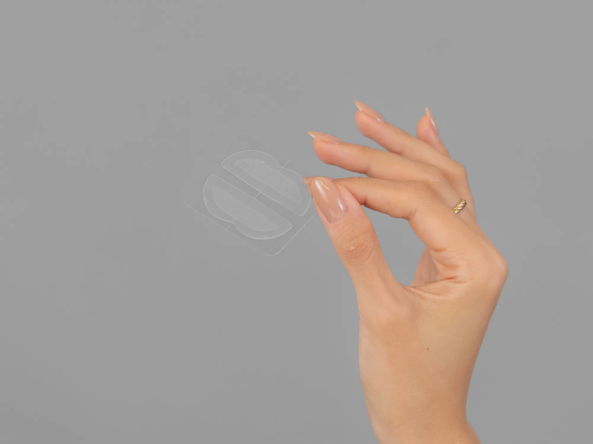 Closeup of Laziza from LAZ Skincare holding up a bottle of KrX Aesthetics Lip Darts