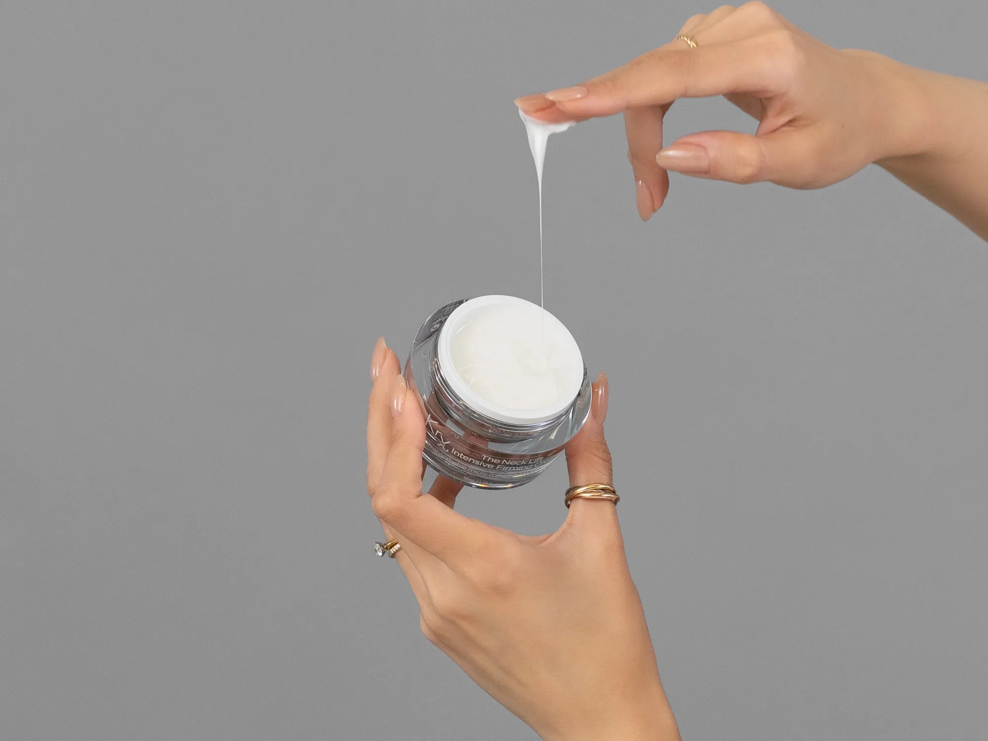 Closeup of Laziza from LAZ Skincare holding up a bottle of KrX Aesthetics Neck Lift Intensive Firming Cream