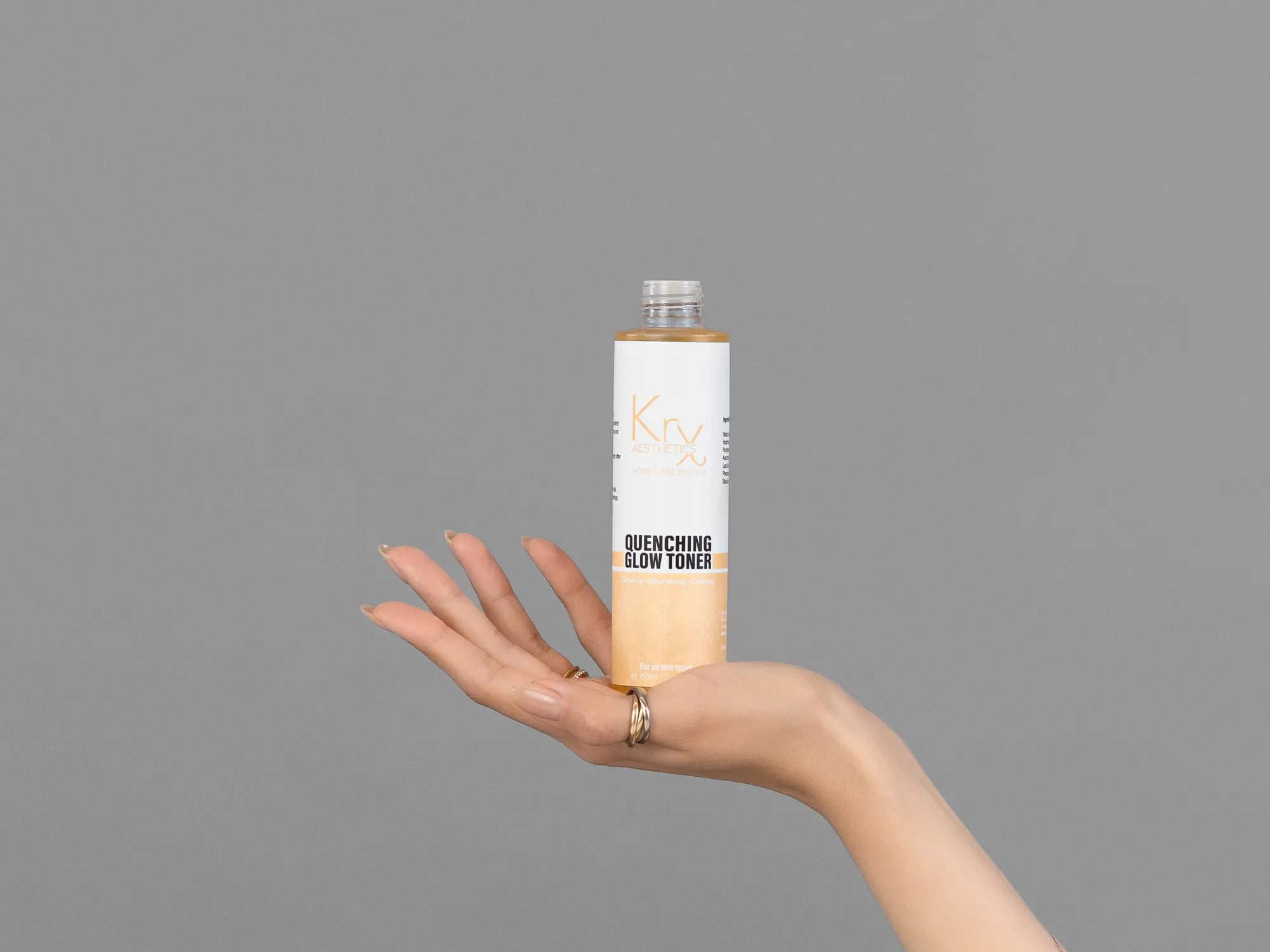 Closeup of Laziza from LAZ Skincare holding up a bottle of KrX Aesthetics Quenching Glow Toner