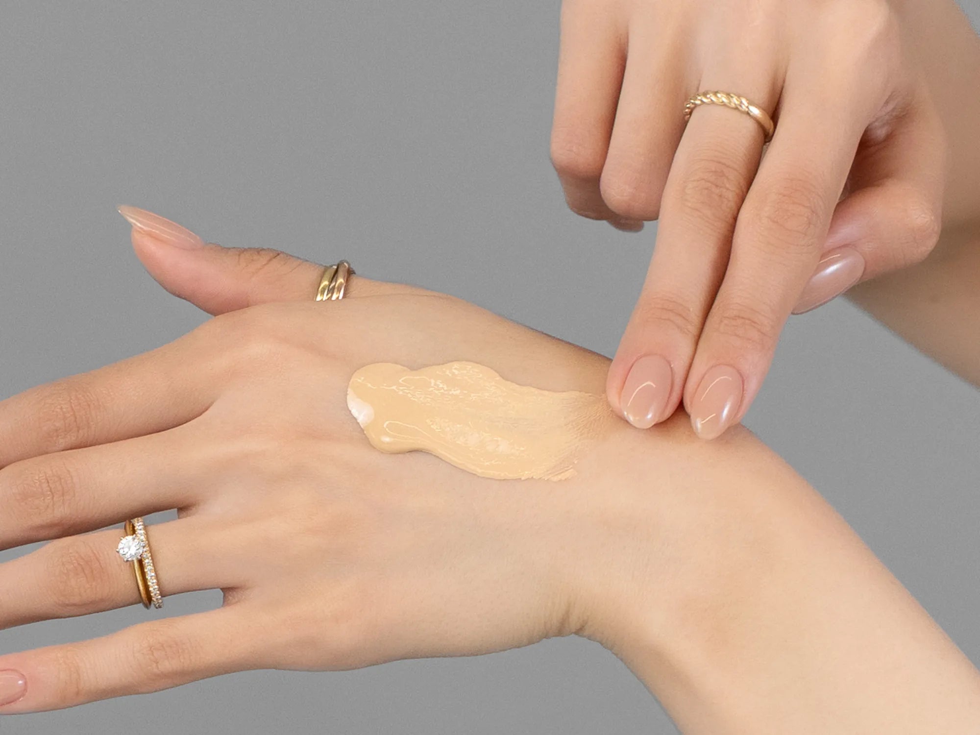 Laziza from LAZ Skincare demonstrating the texture and application of KrX Aesthetics Skin Filter Tinted Sunscreen SPF 50 on her hand