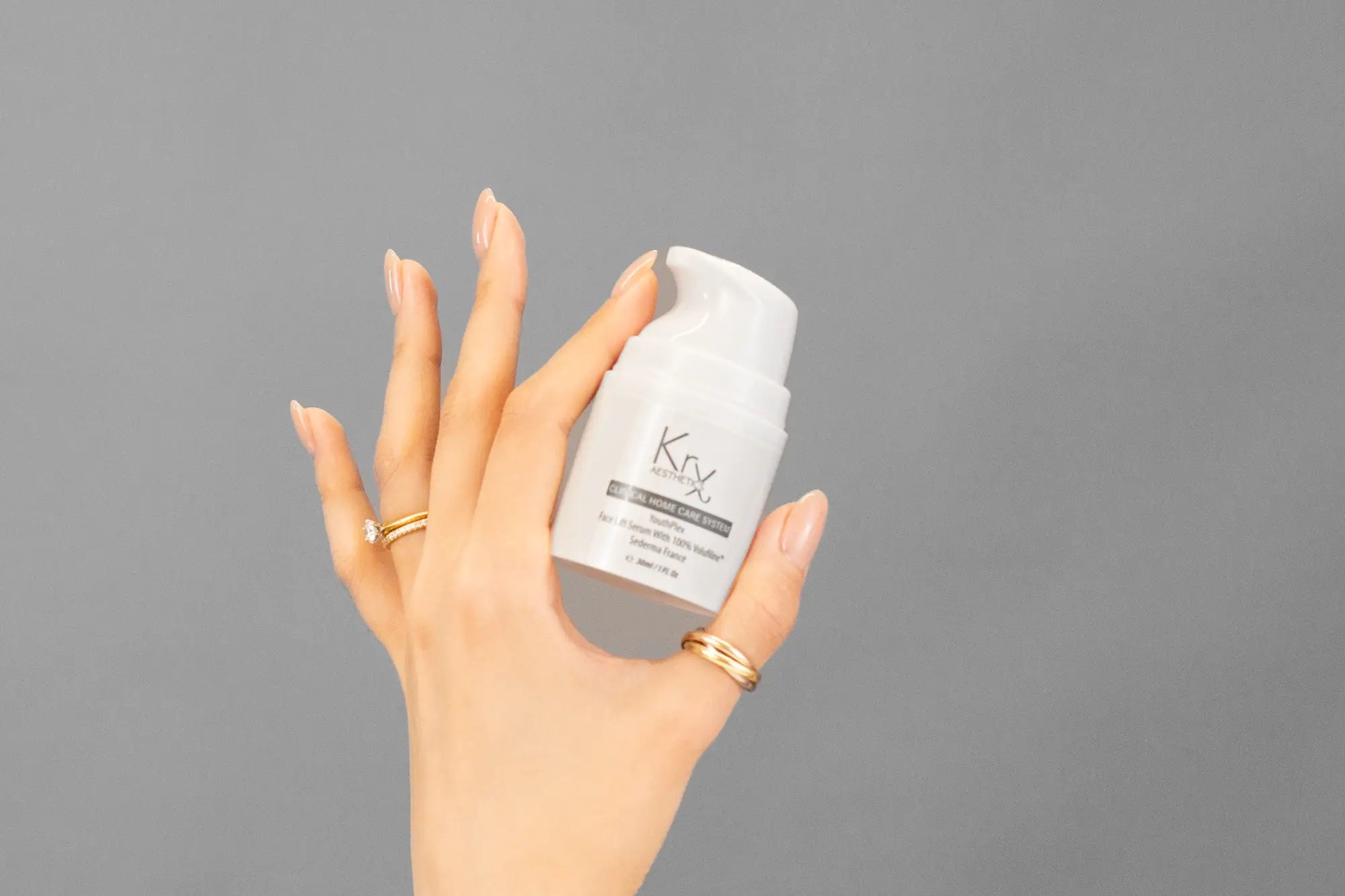 Closeup of Laziza from LAZ Skincare holding up a bottle of KrX Aesthetics Youthplex Face Lift Serum