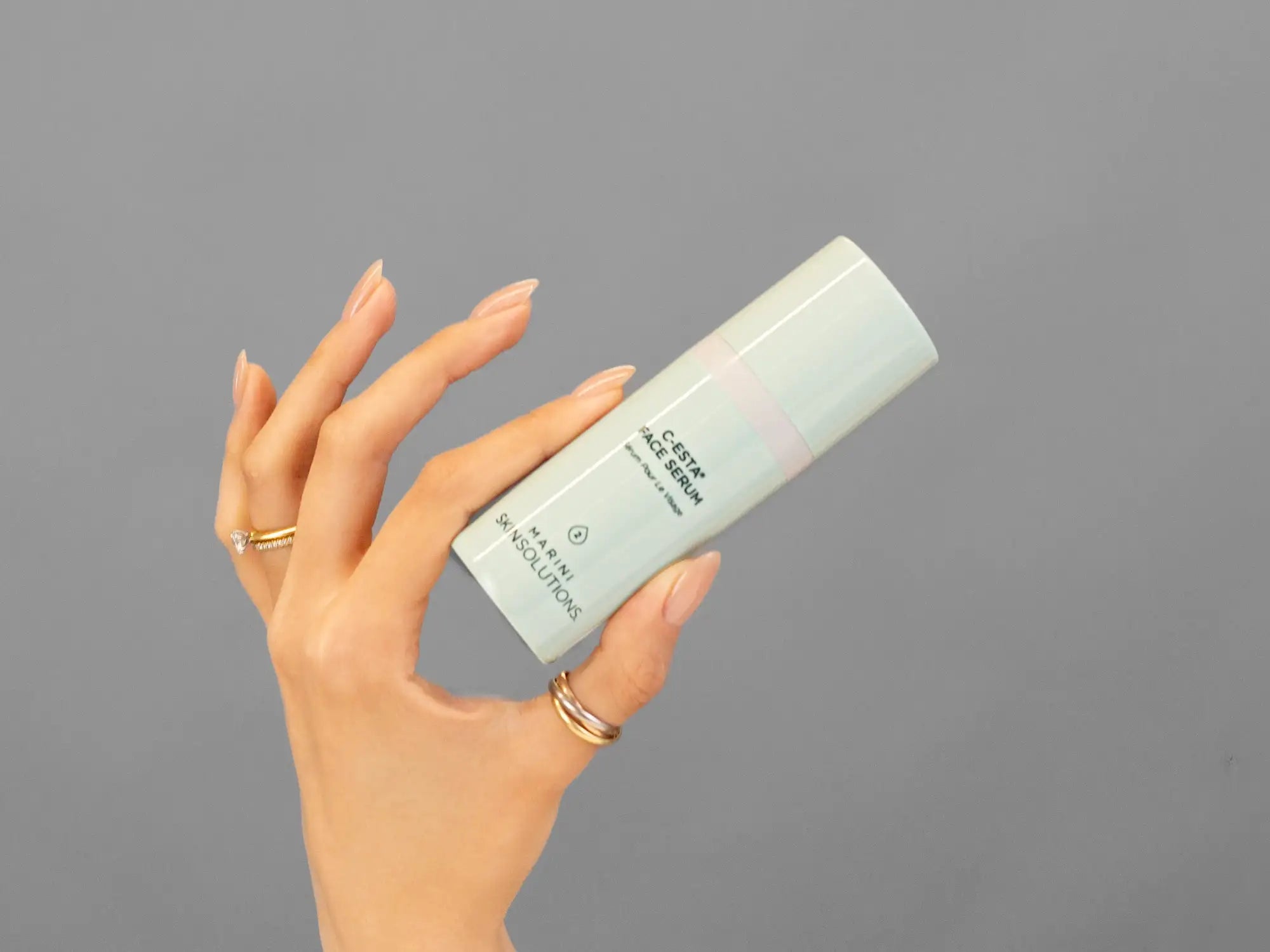 Closeup of Laziza from LAZ Skincare holding up a bottle of Marini SkinSolutions C-Esta Face Serum