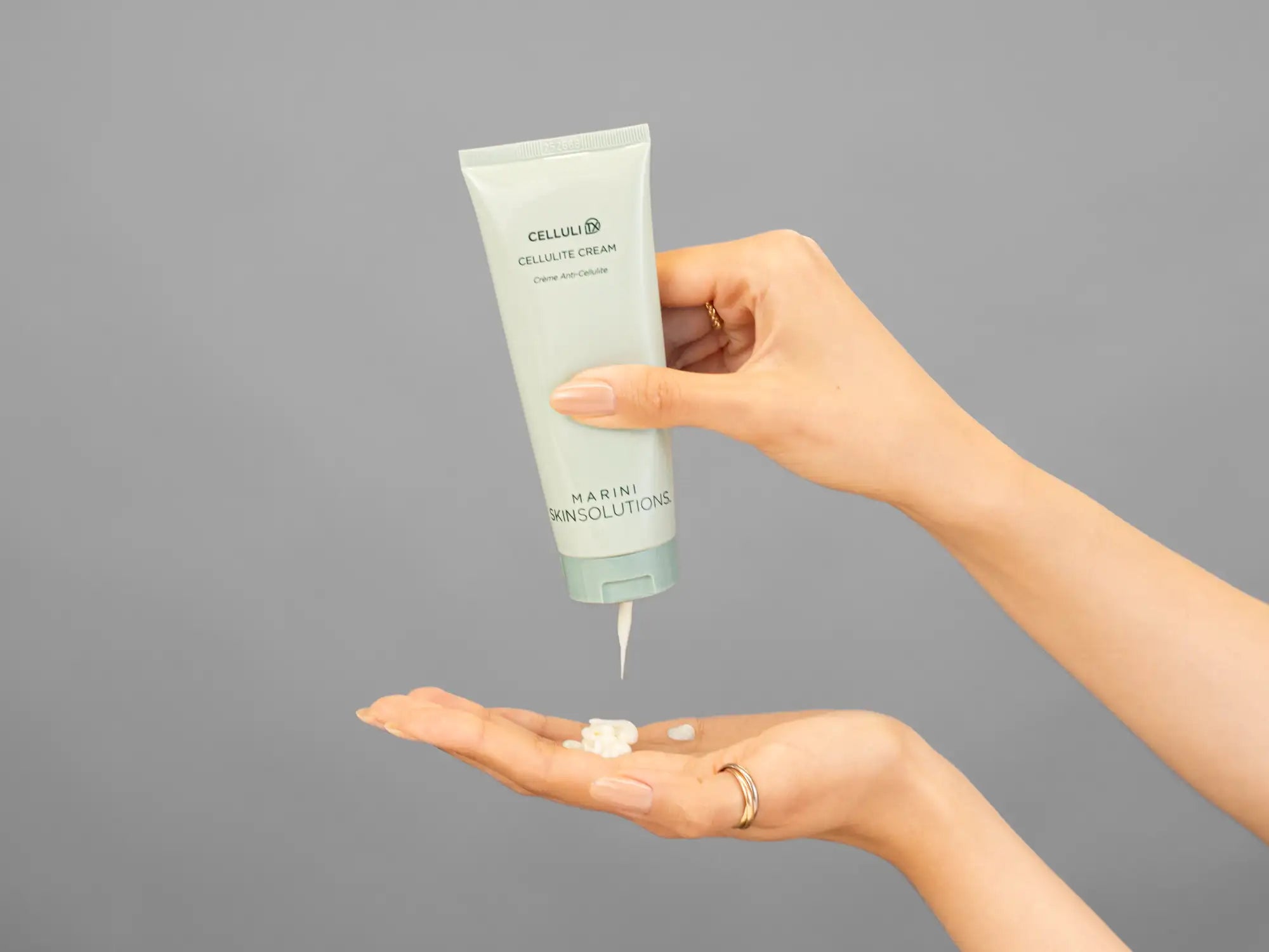Closeup of Laziza from LAZ Skincare holding up a bottle of Marini SkinSolutions CelluliTx