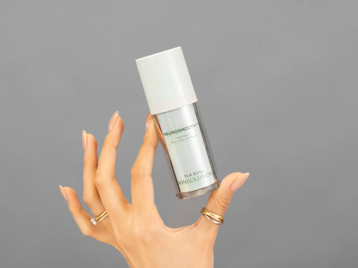 Closeup of Laziza from LAZ Skincare holding up a bottle of Marini SkinSolutions NeuroSmooth