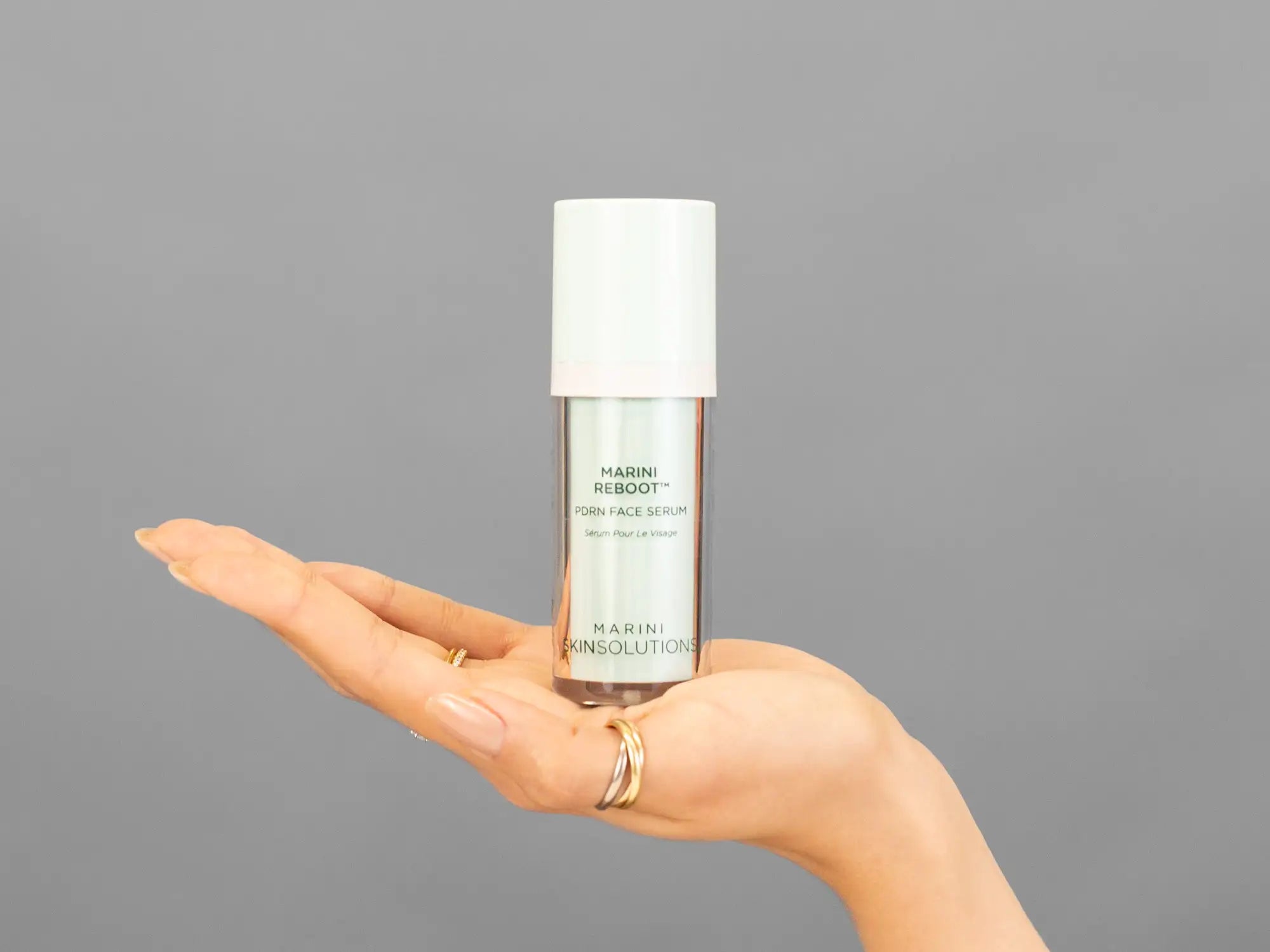 Closeup of Laziza from LAZ Skincare holding up a bottle of Marini SkinSolutions Marini Reboot PDRN Face Serum