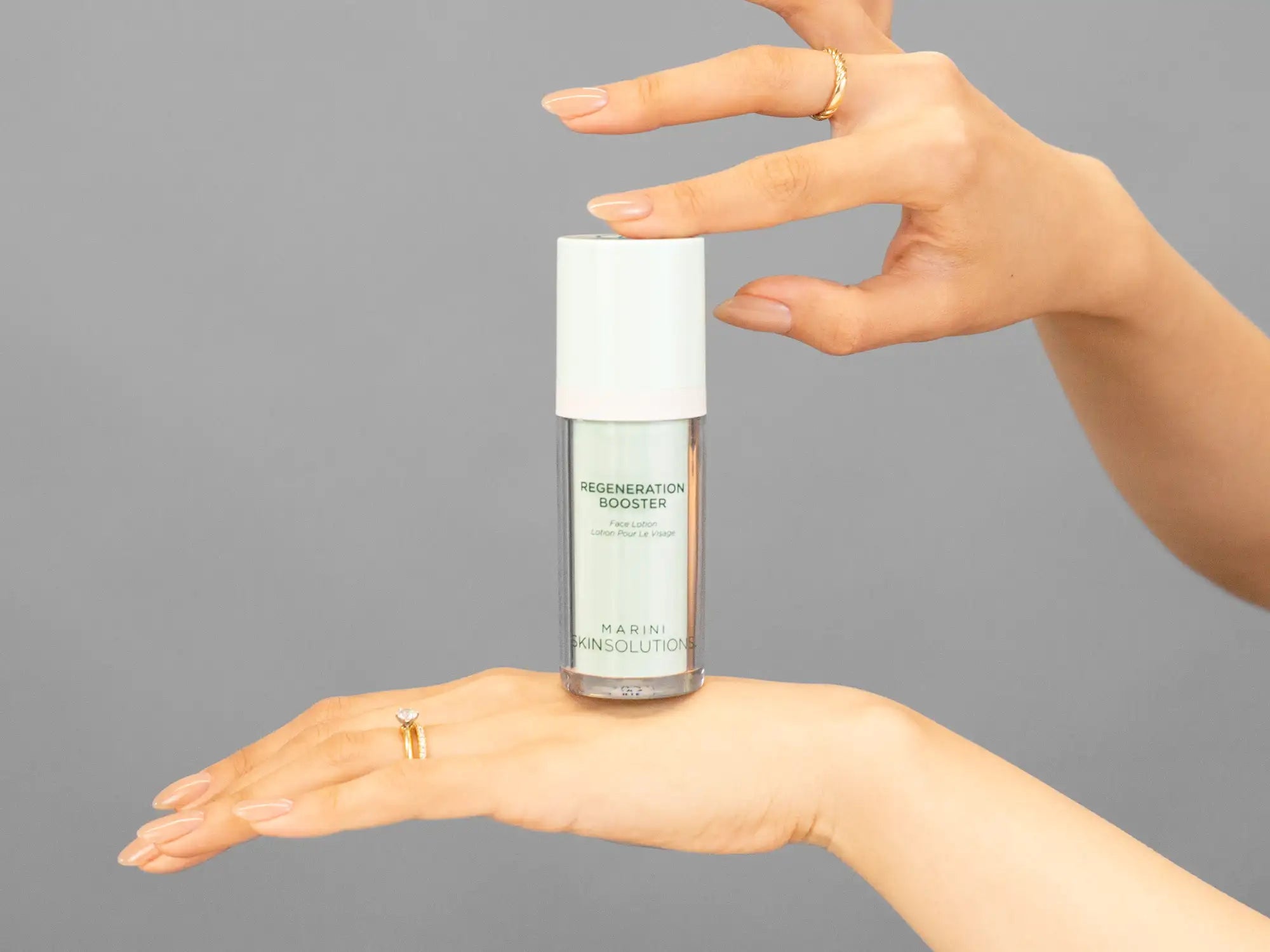 Closeup of Laziza from LAZ Skincare holding up a bottle of Marini SkinSolutions Regeneration Booster