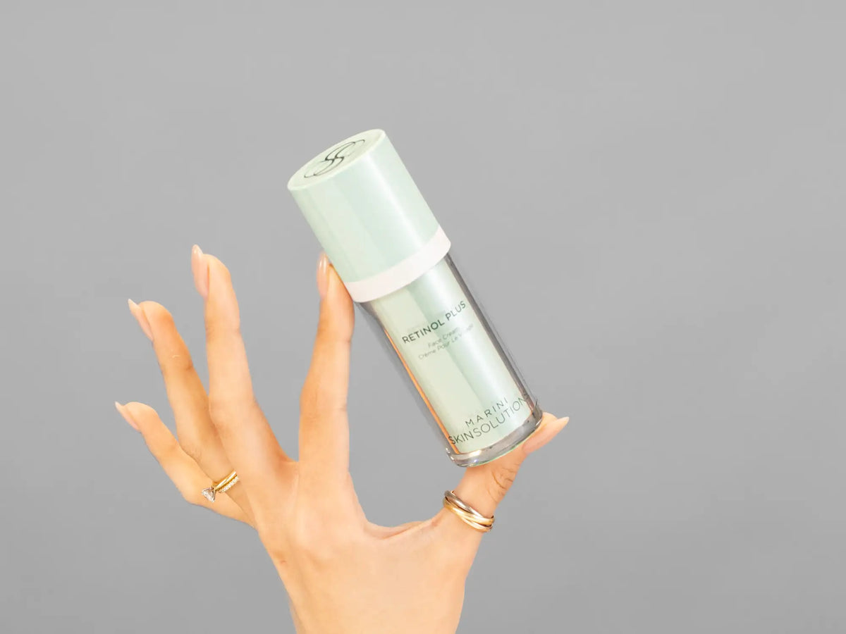 Closeup of Laziza from LAZ Skincare holding up a bottle of Marini SkinSolutions Retinol Plus