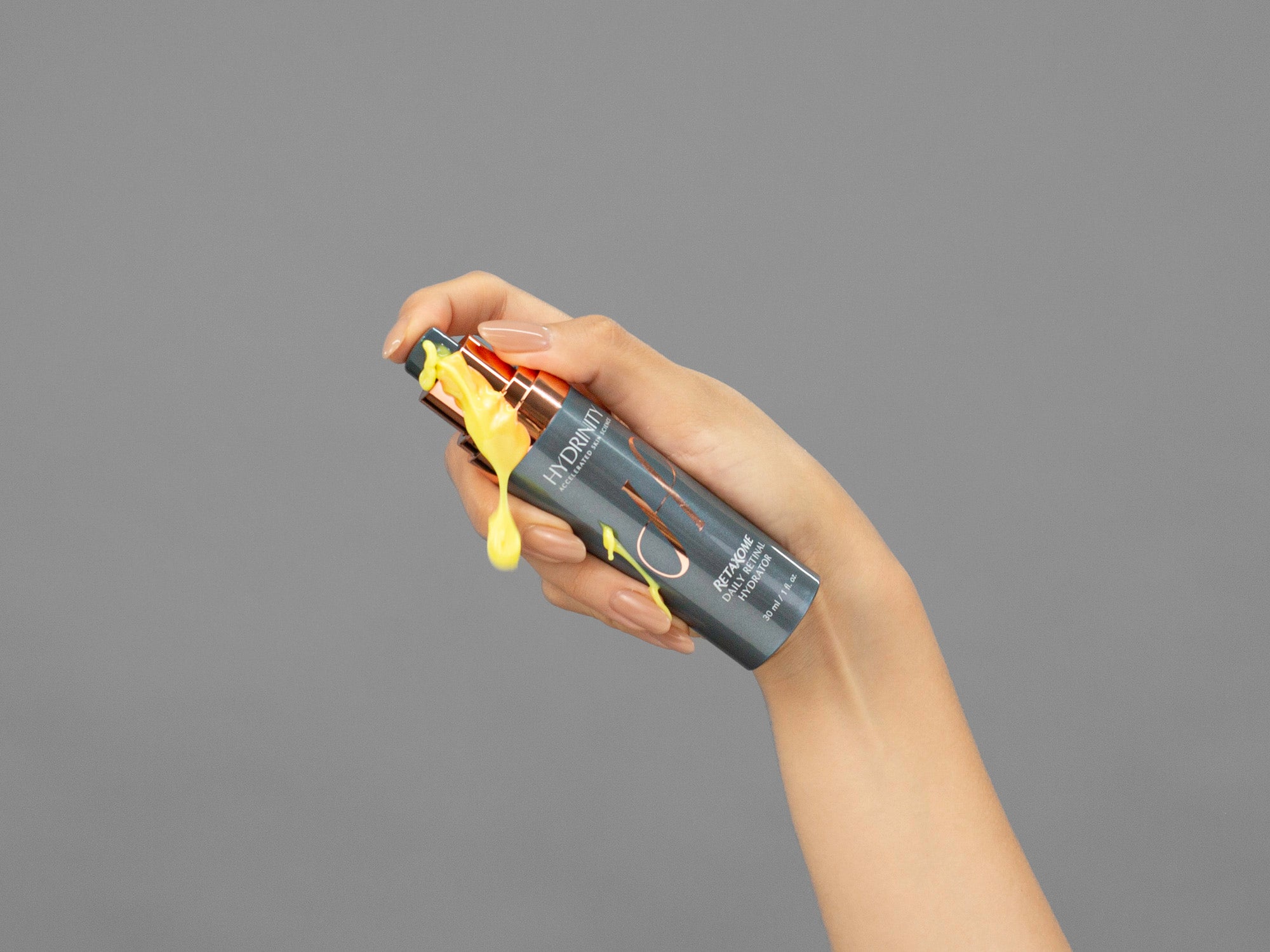 Closeup of Laziza from LAZ Skincare holding a bottle of Hydrinity Retaxome Daily Retinal Hydrator in her hand