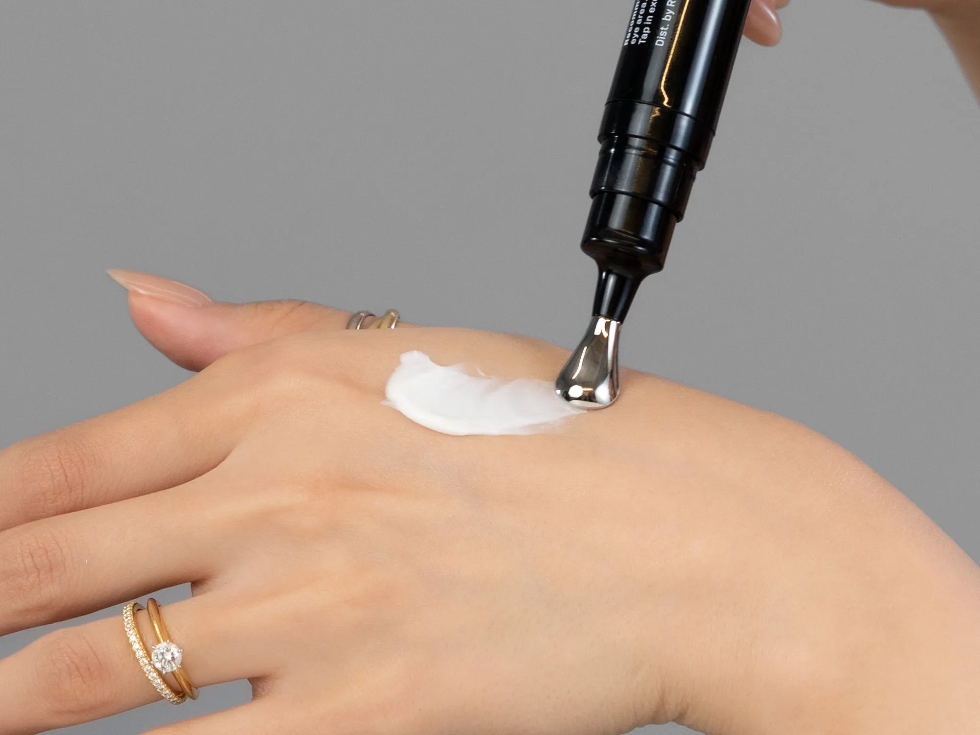 Laziza from LAZ Skincare demonstrating the texture and application of Revision D·E·J Eye Cream on her hand