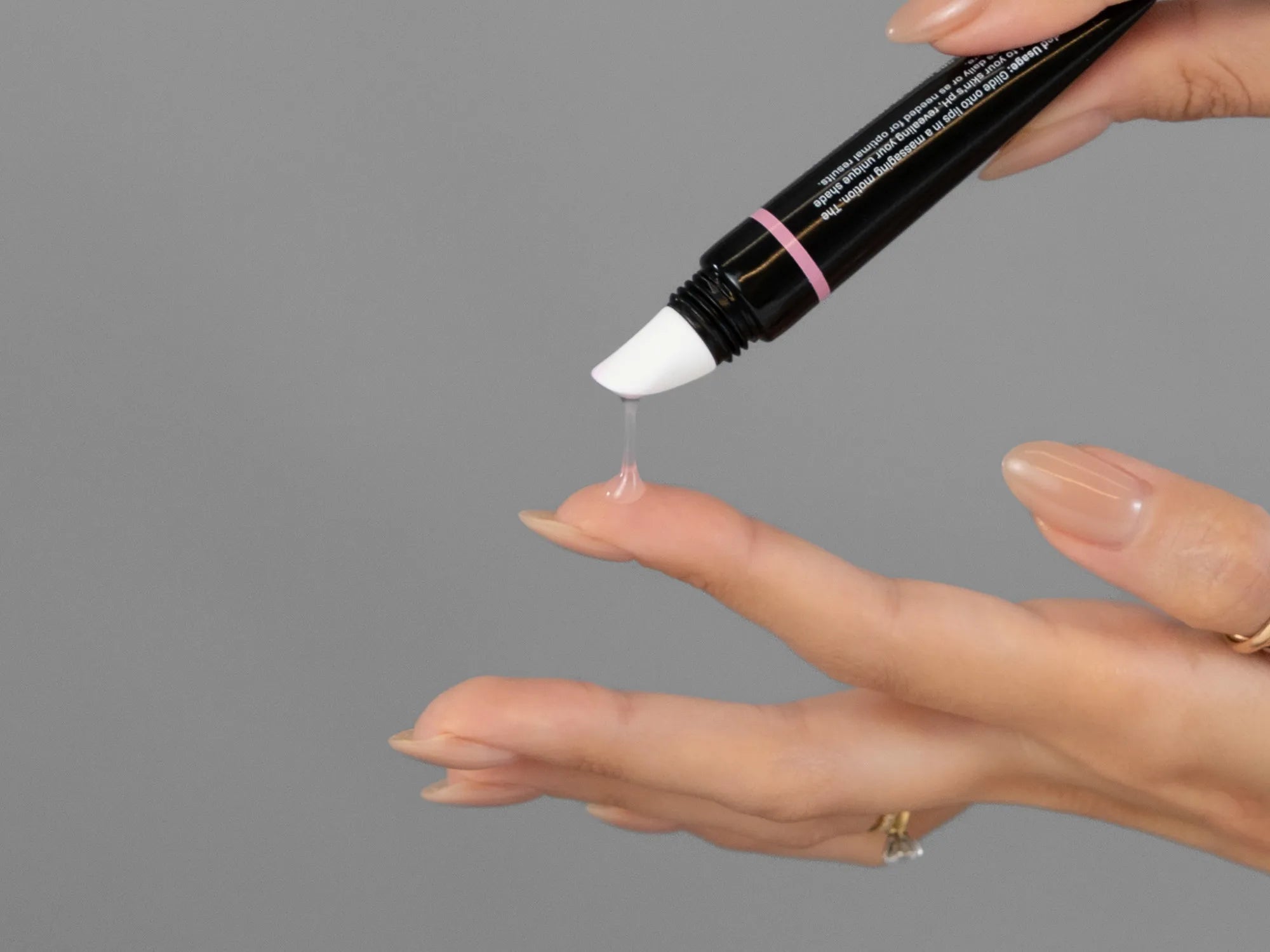 Laziza from LAZ Skincare demonstrating the texture and application of Revision Youthfull Lip Replenisher on her hand