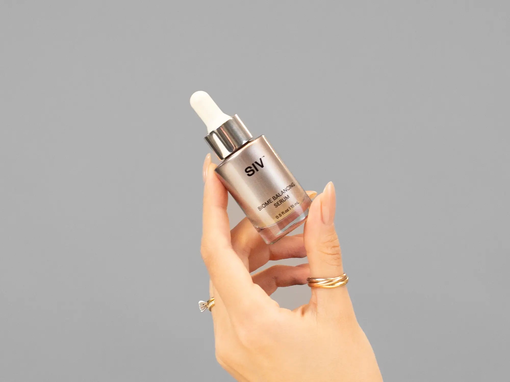 Closeup of Laziza from LAZ Skincare holding up a bottle of SIV Biome Balancing Serum
