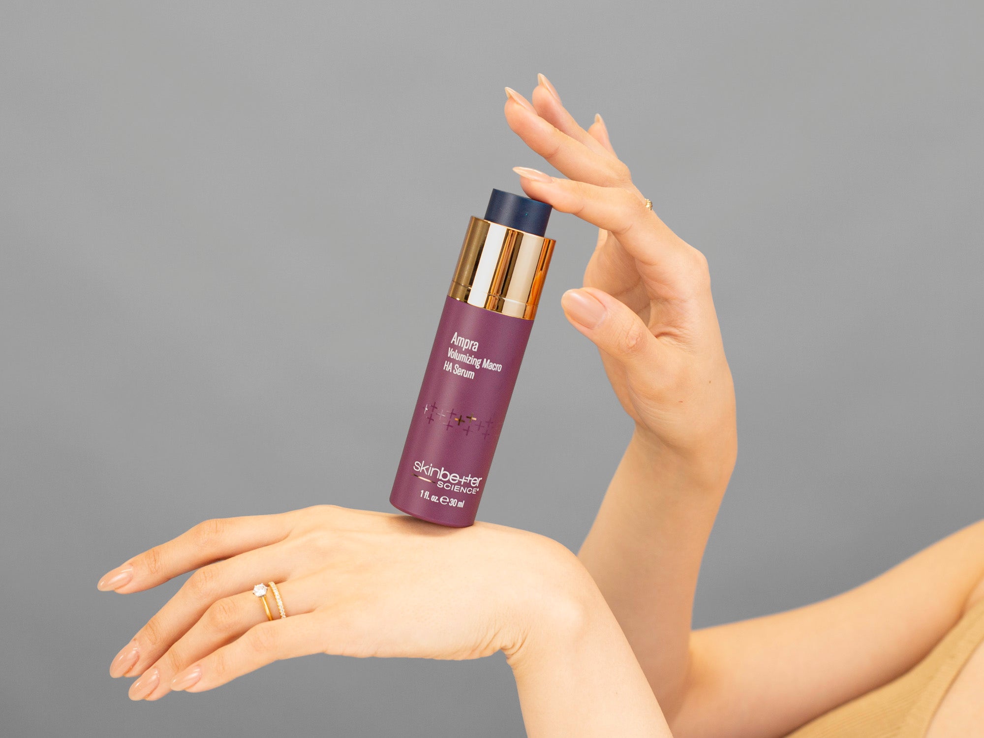 Closeup of Laziza from LAZ Skincare holding up a bottle of SkinBetter Science Ampra Volumizing Serum