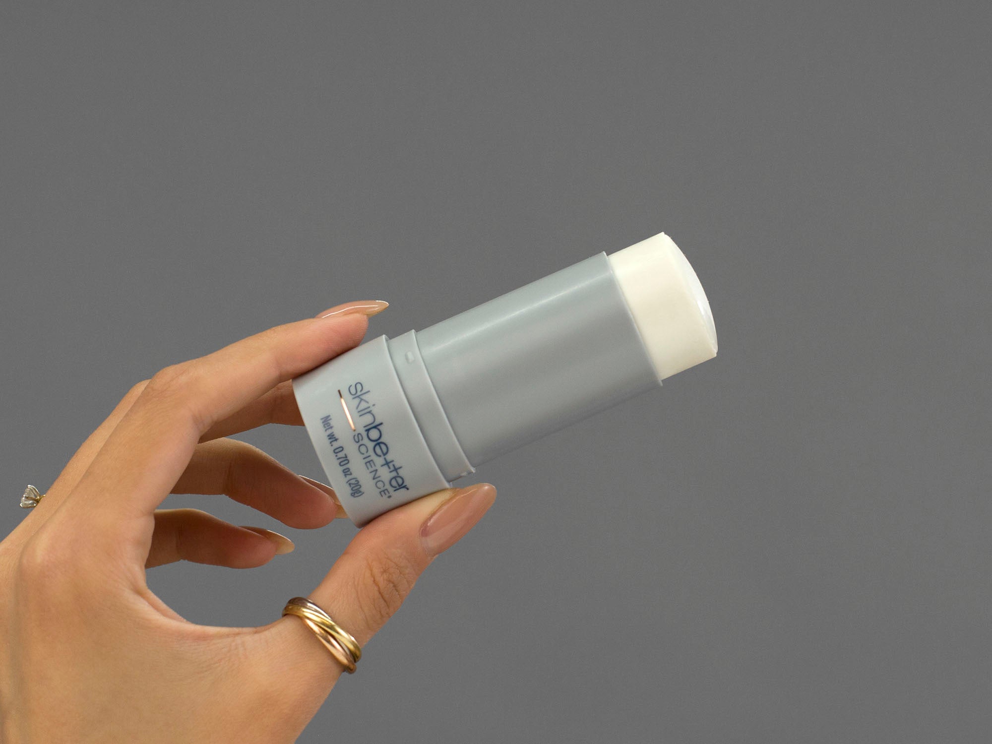 Closeup of Laziza from LAZ Skincare holding up a bottle of SkinBetter Science sunbetter SHEER SPF 56 Sunscreen Stick