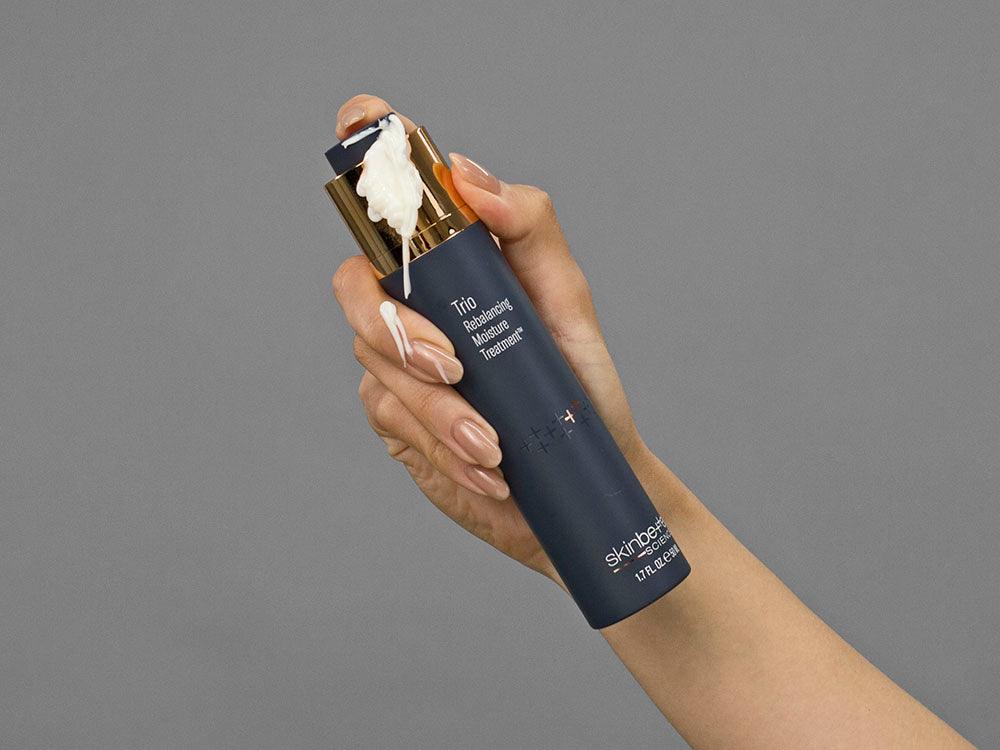Closeup of Laziza from LAZ Skincare holding up a bottle of SkinBetter Science Trio Rebalancing Moisture Treatment