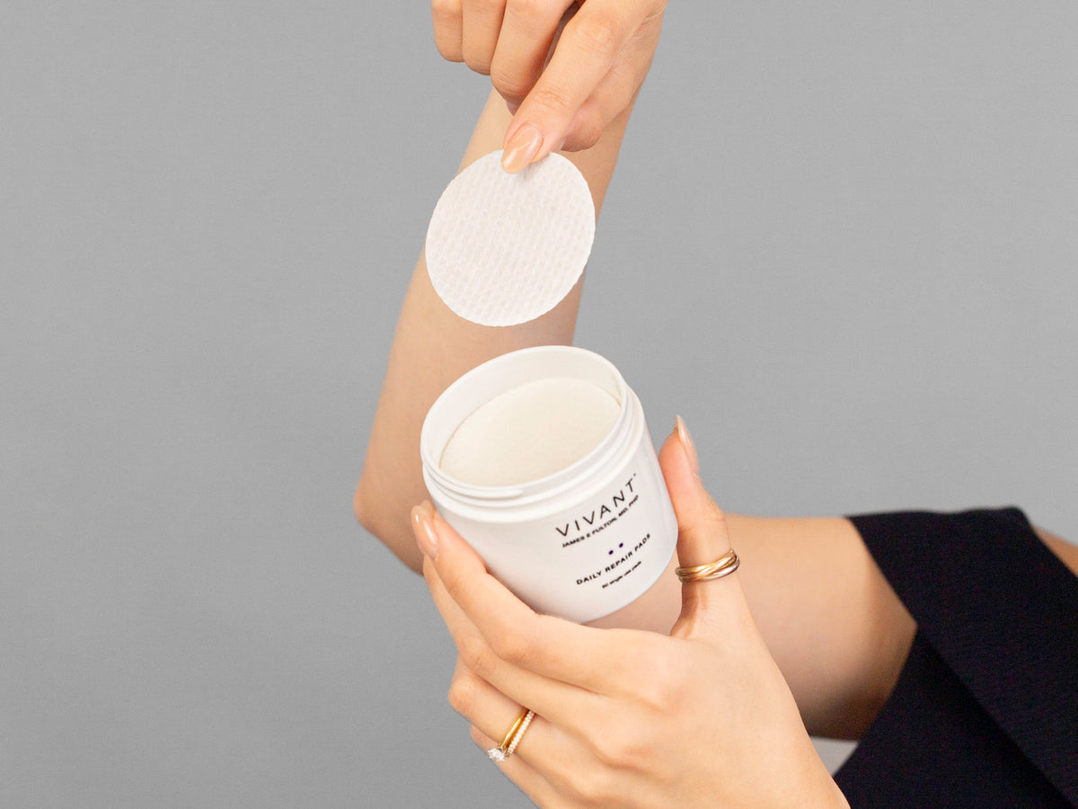 Closeup of Laziza from LAZ Skincare holding up a bottle of Vivant Daily Repair Pads