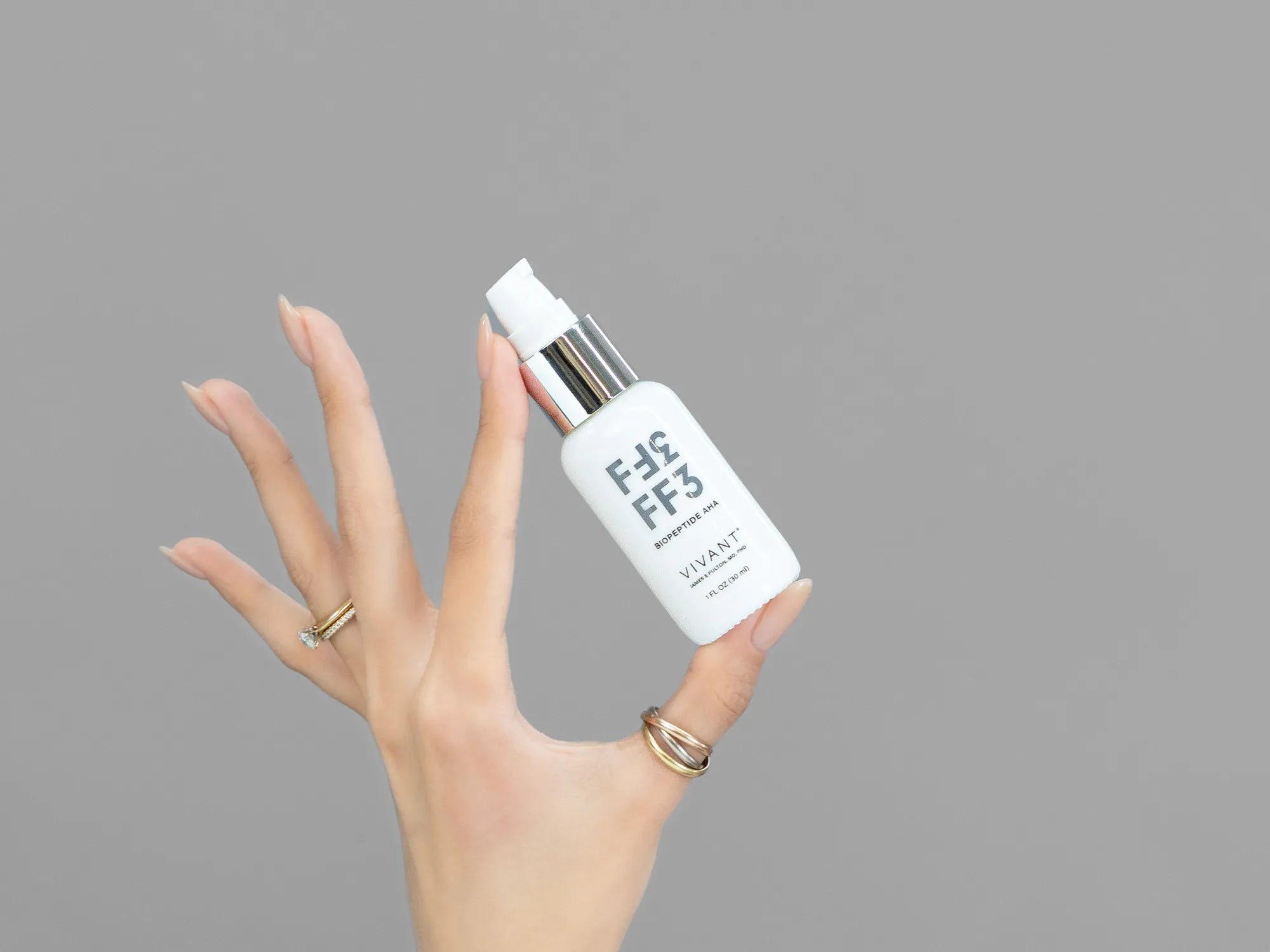 Closeup of Laziza from LAZ Skincare holding up a bottle of Vivant FF3 BioPeptide AHA