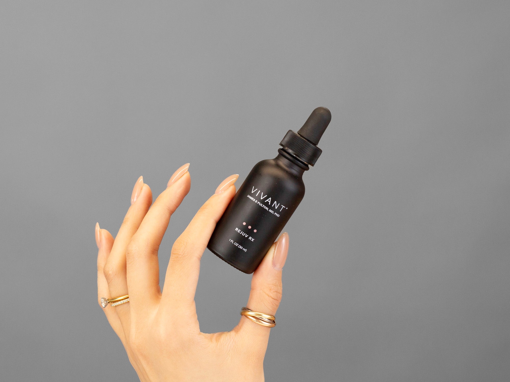 Closeup of Laziza from LAZ Skincare holding a bottle  of Vivant Rejuv Rx in her hand