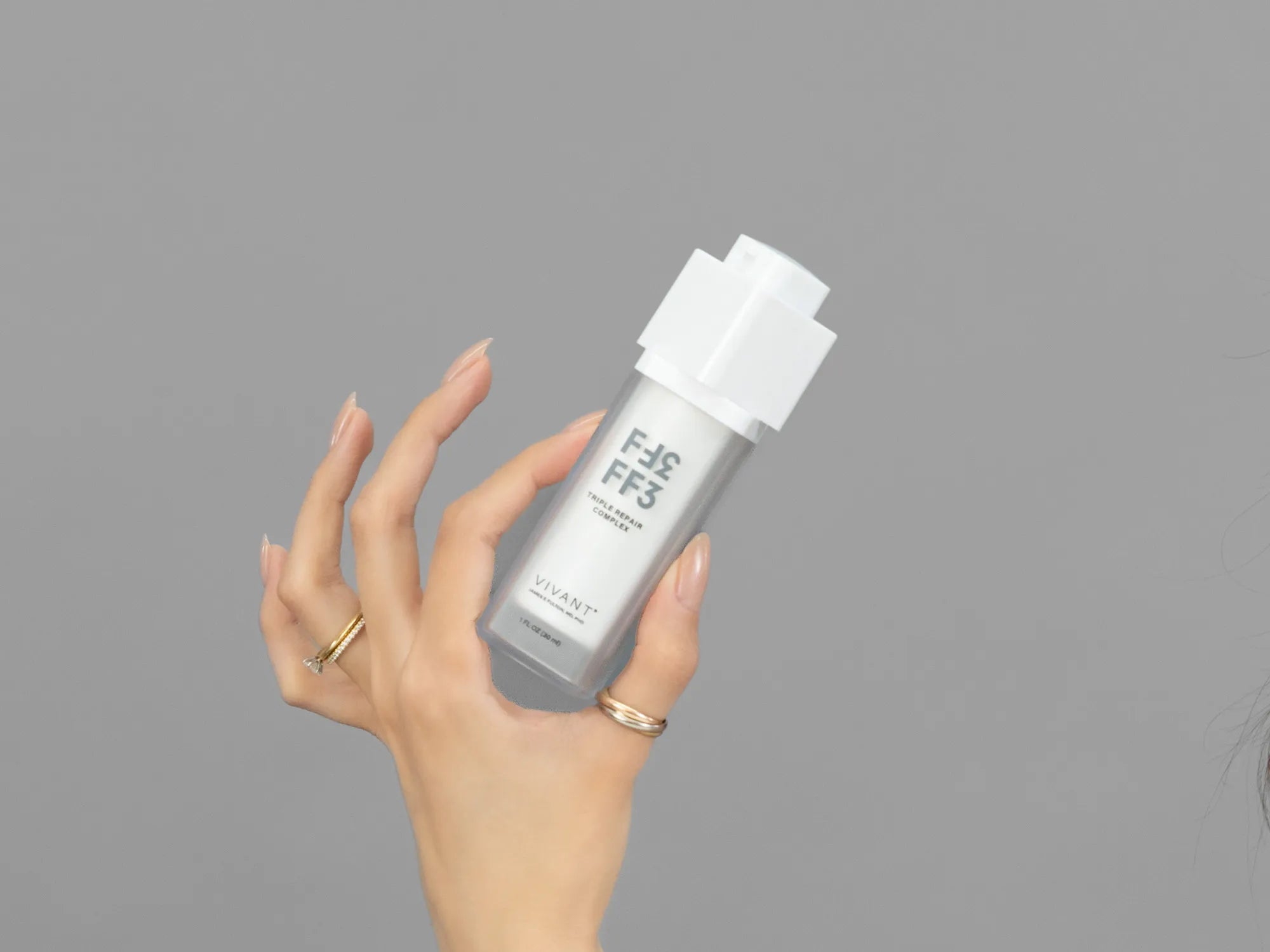 Closeup of Laziza from LAZ Skincare holding up a bottle of Vivant FF3 Triple Repair Complex