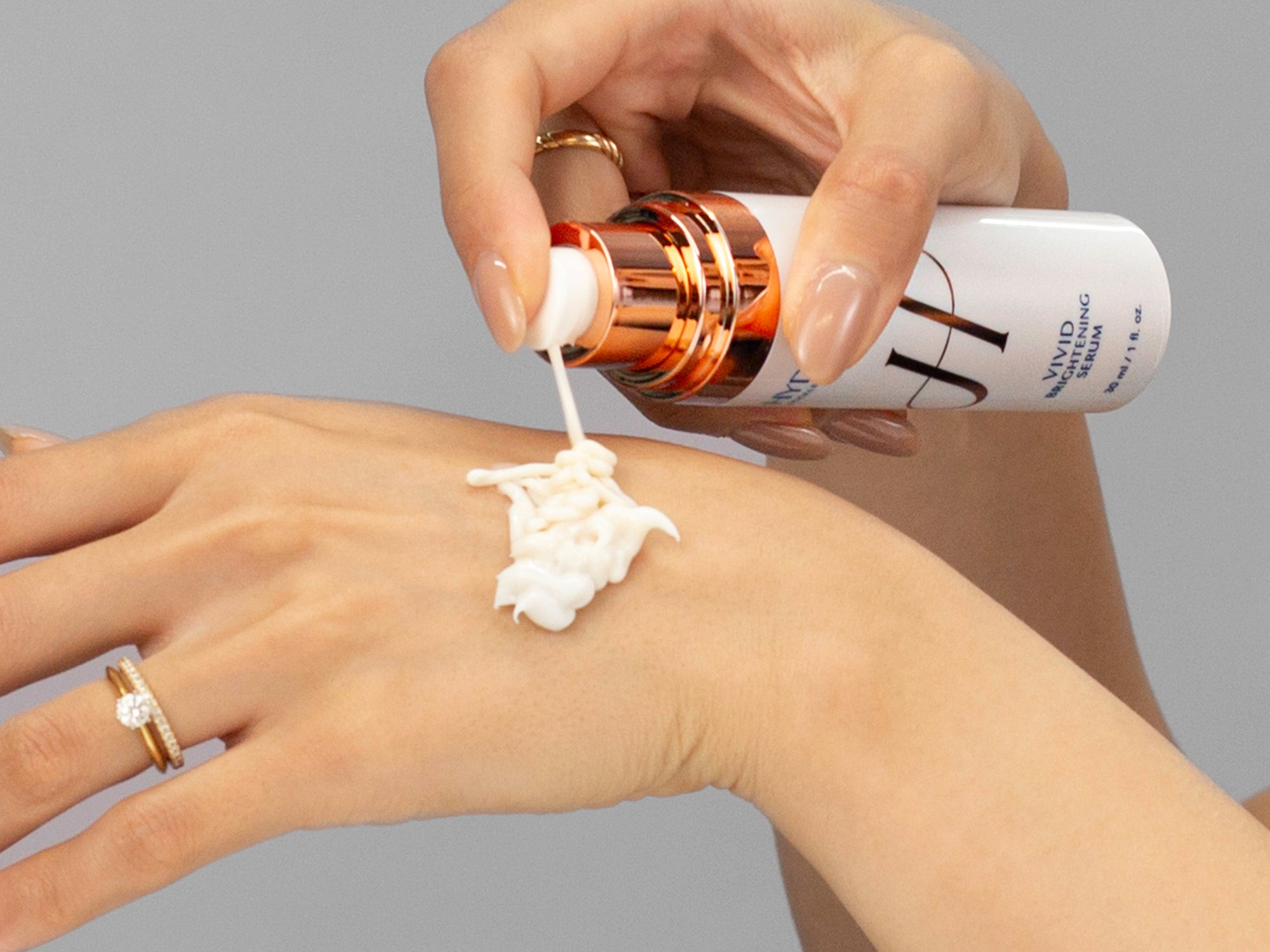 Closeup of Laziza from LAZ Skincare applying Hydrinity Vivid Brightening Serum to her hand