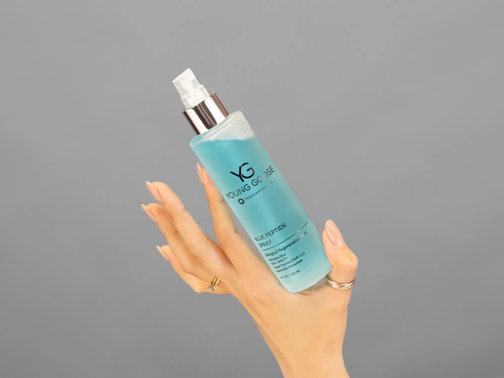 Closeup of Laziza from LAZ Skincare holding up a bottle of Young Goose Blue Peptide Spray