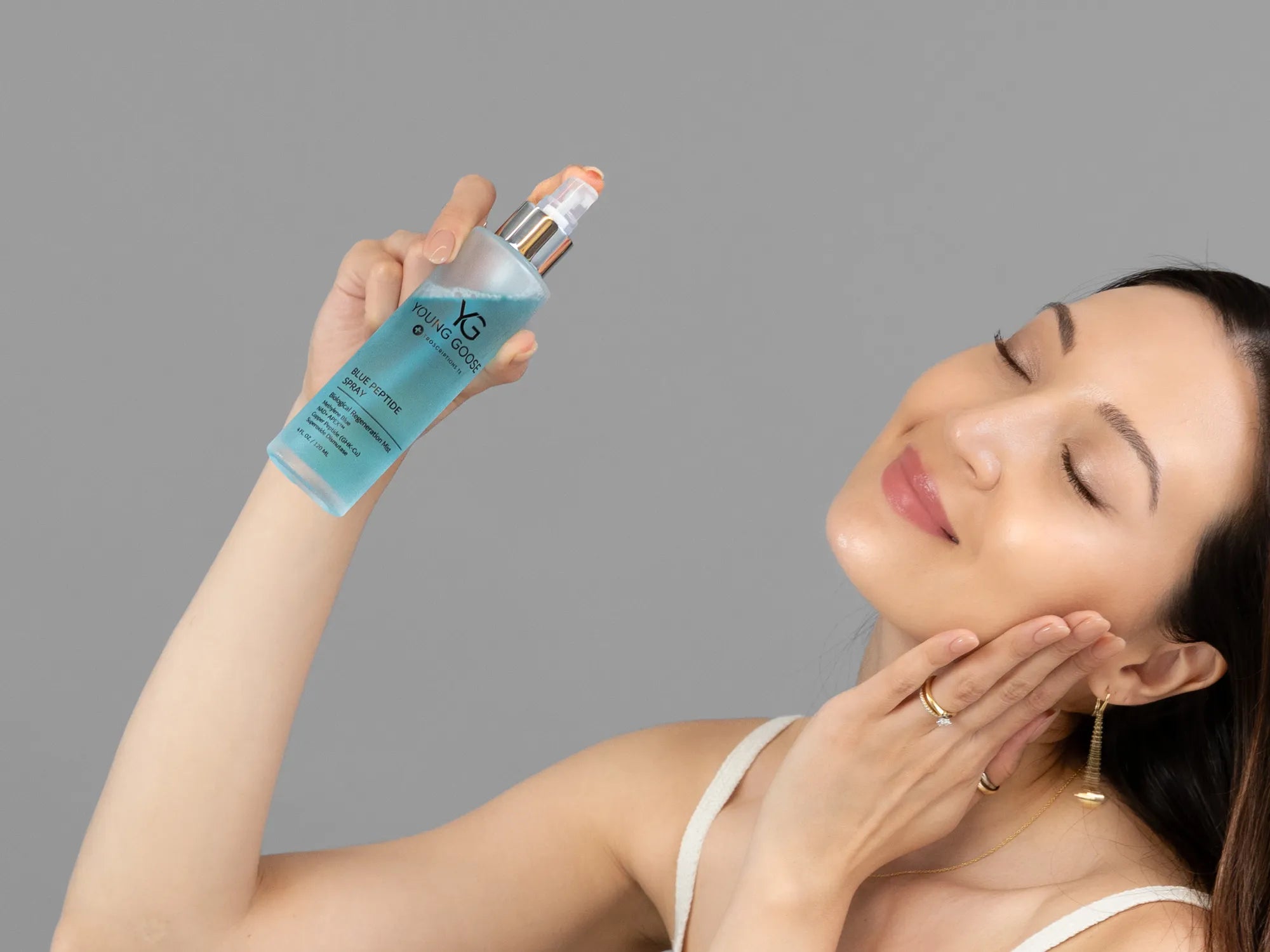 Laziza from LAZ Skincare demonstrating the texture and application of Young Goose Blue Peptide Spray on her hand