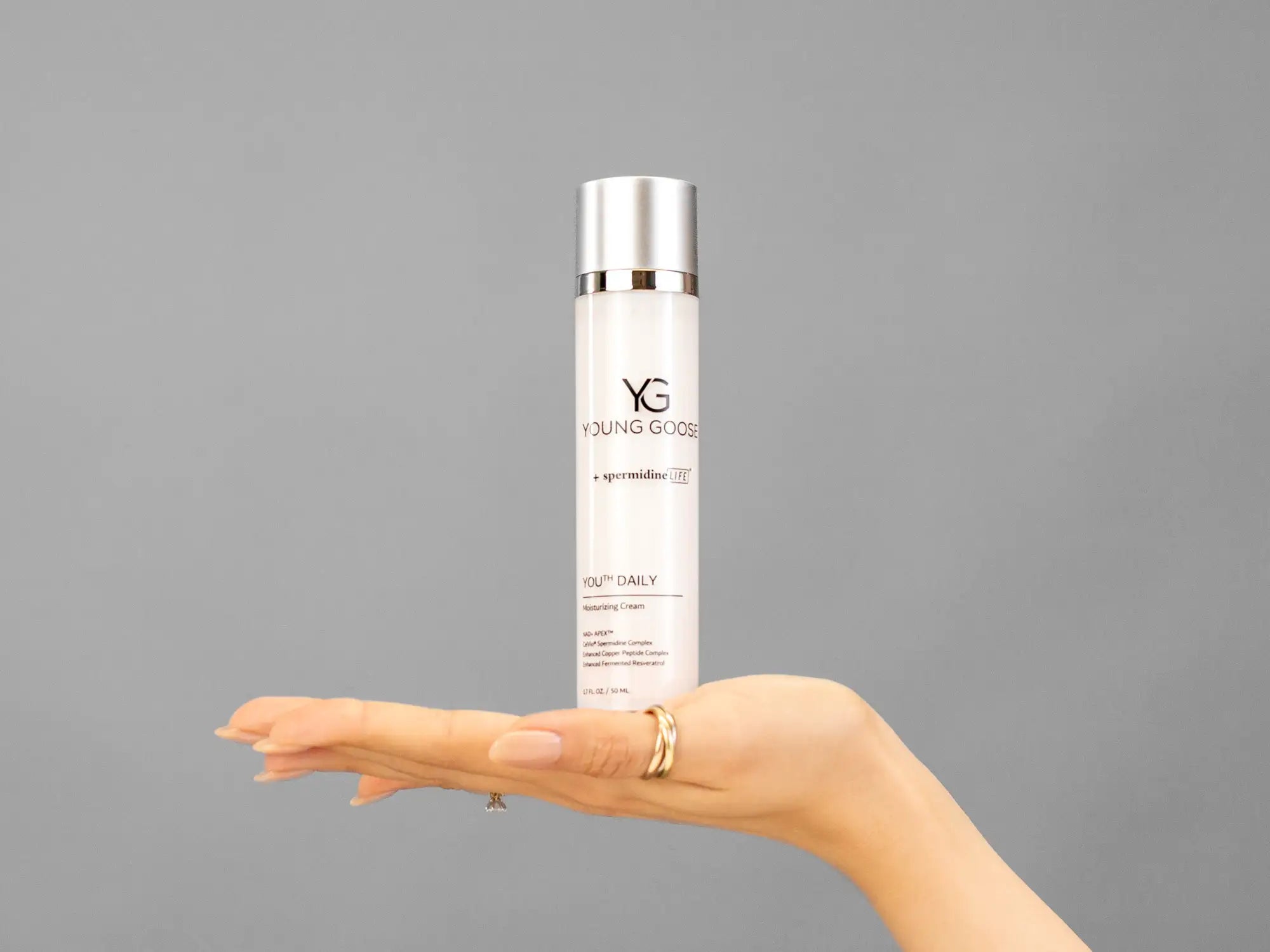 Closeup of Laziza from LAZ Skincare holding up a bottle of Young Goose Youth Daily