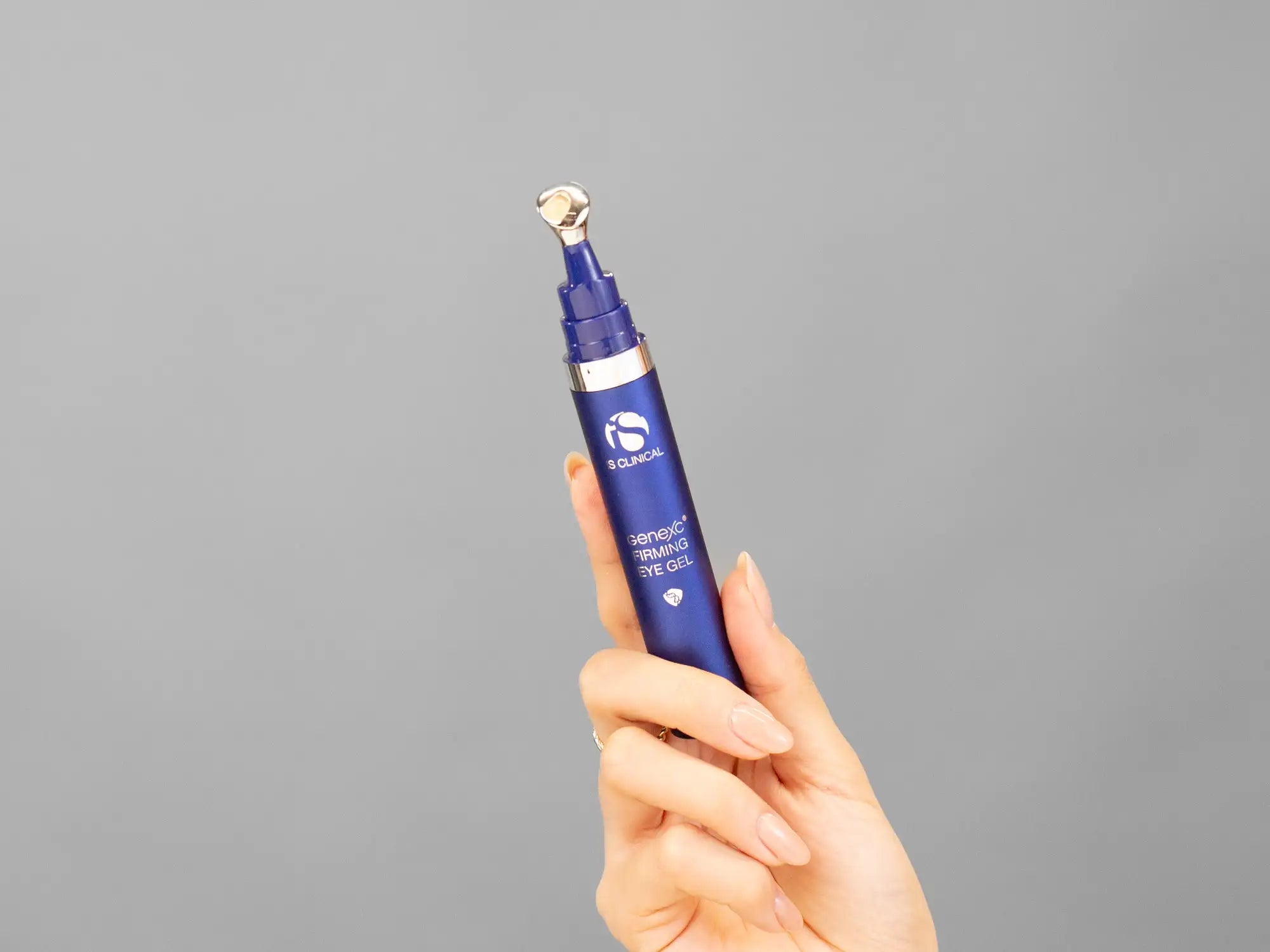 Closeup of Laziza from LAZ Skincare holding up a bottle of iS Clinical GeneXC Firming Eye Gel