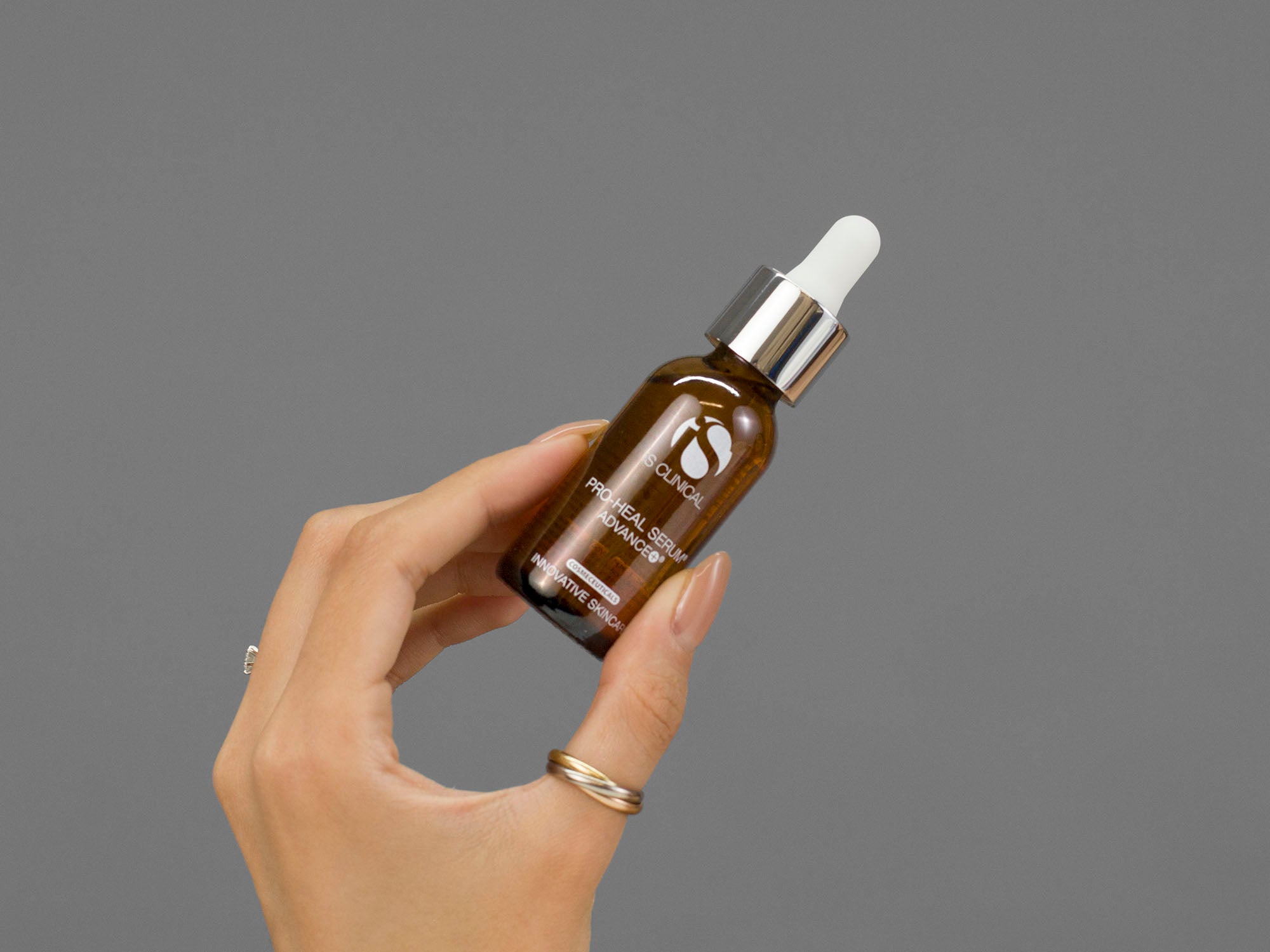 Closeup of Laziza from LAZ Skincare holding up a bottle of iS Clinical Pro-Heal Serum Advance+